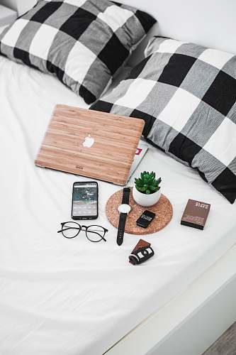 blanket smartphone, eyeglasses, watch, and vehicle fob on bed timișoara